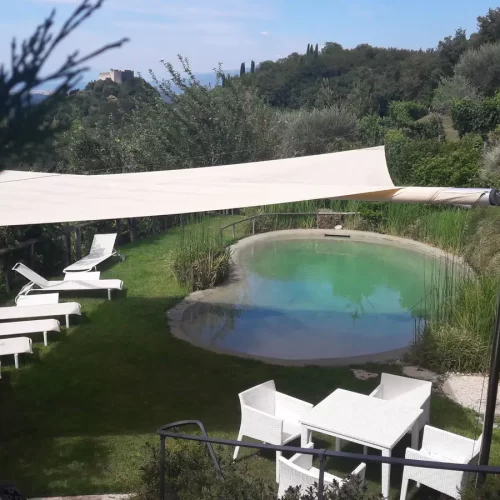 Vela avvolgibile in apertura automatica per creare zona d'obra sulle sponde di un laghetto