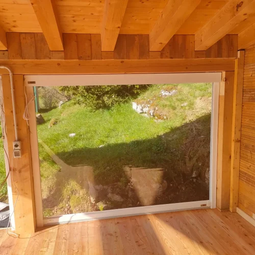 Stanza di una casa con pavimento e soffitto in legno e chiusura con vetrotenda Sky