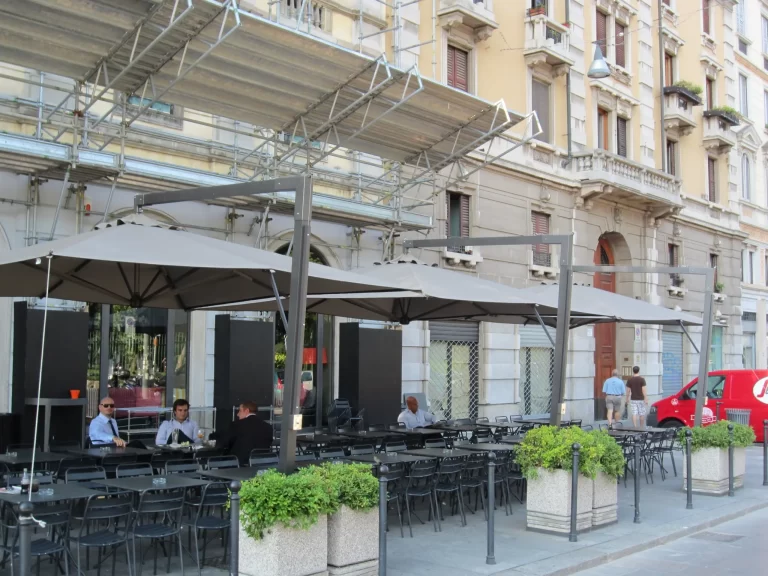 Ombrelloni a palo laterale sul dehors di un bar in città