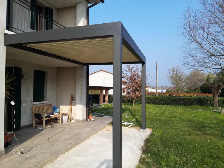 Pergola bioclimatica addossata alla facciata di una casa