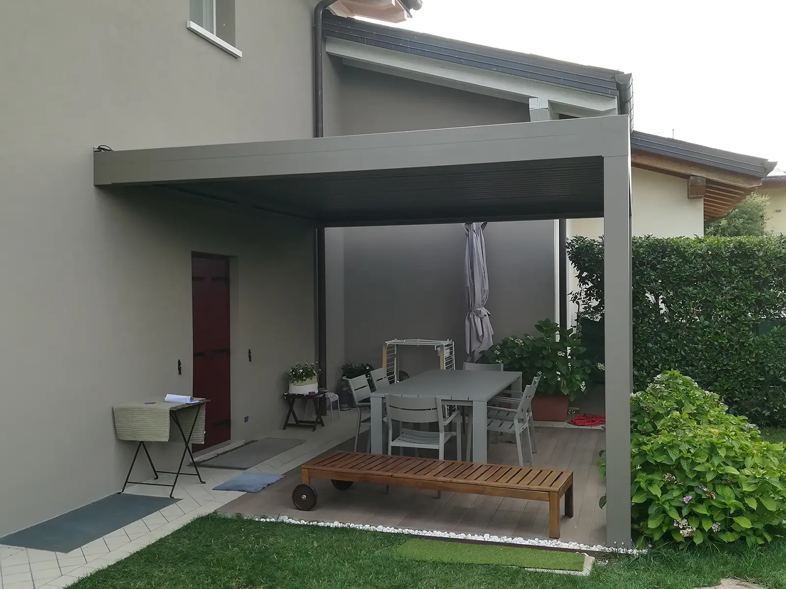 Tecnozen foto di pergola bioclimatica orientabile 4.0 addossata su spazio esterno di una casa privata