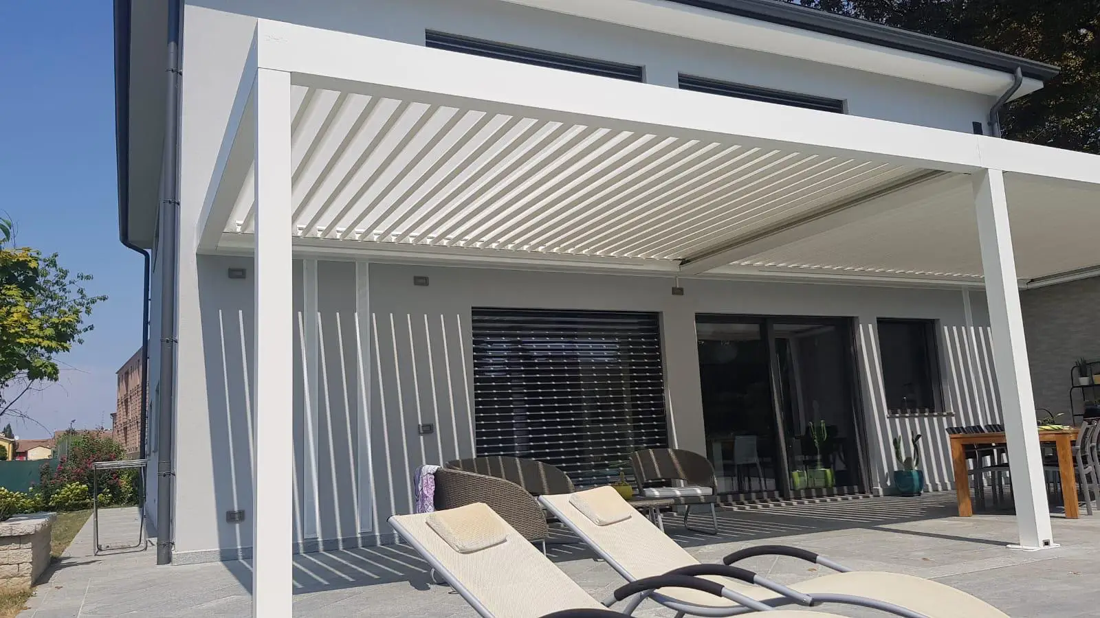 Pergola bioclimatica orientabile addossata 5.0 bianca con copertura leggermente aperta